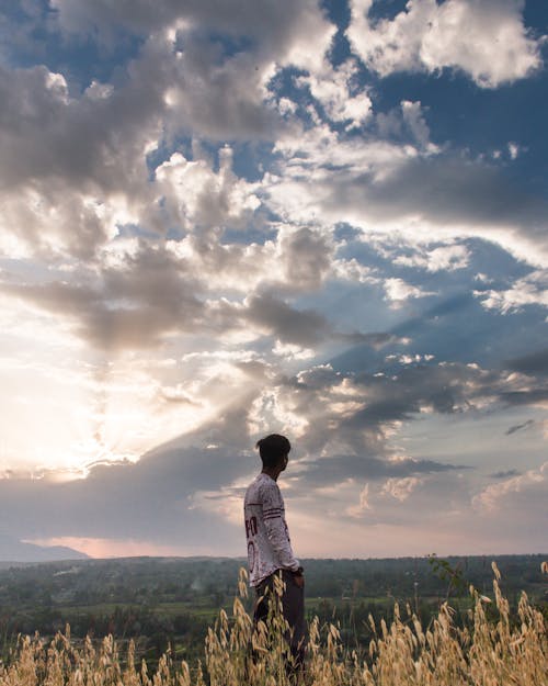 Clouds on Sky over Standing Man at Sunset