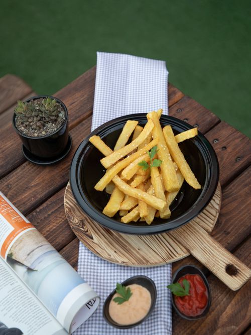 Free Delicious french fries served with sauces on a rustic wooden table in Tehran. Stock Photo
