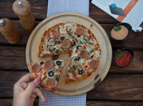 Top View of Woman Taking a Slice of Pizza 