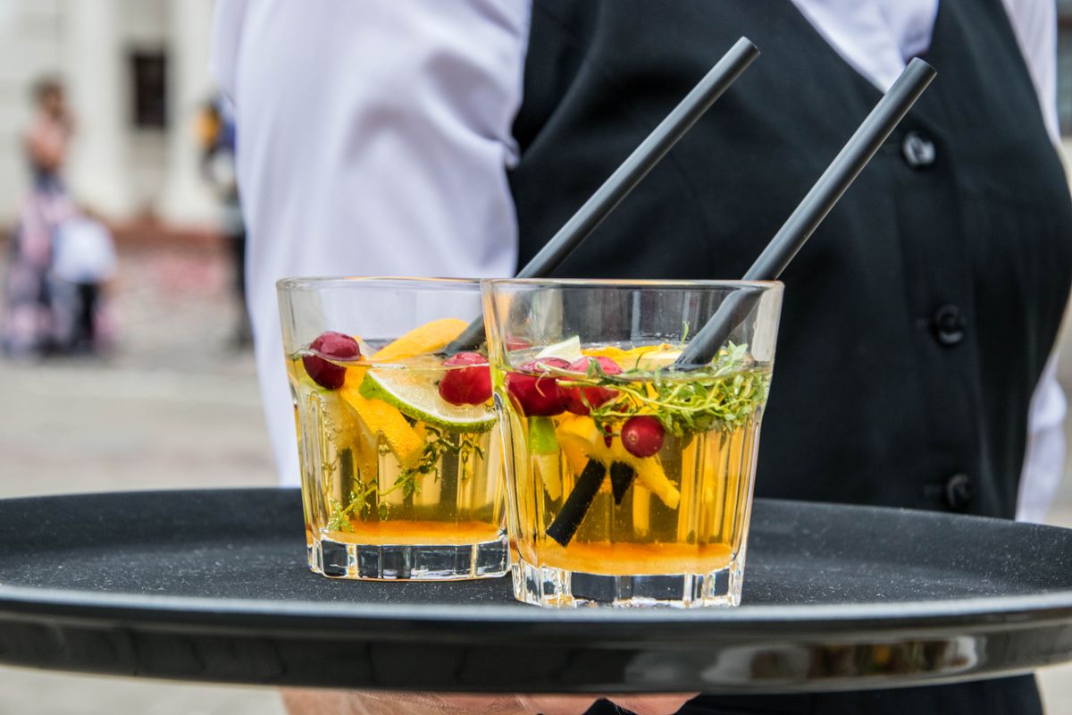 Orange cocktails with cranberries and herbs served on a tray