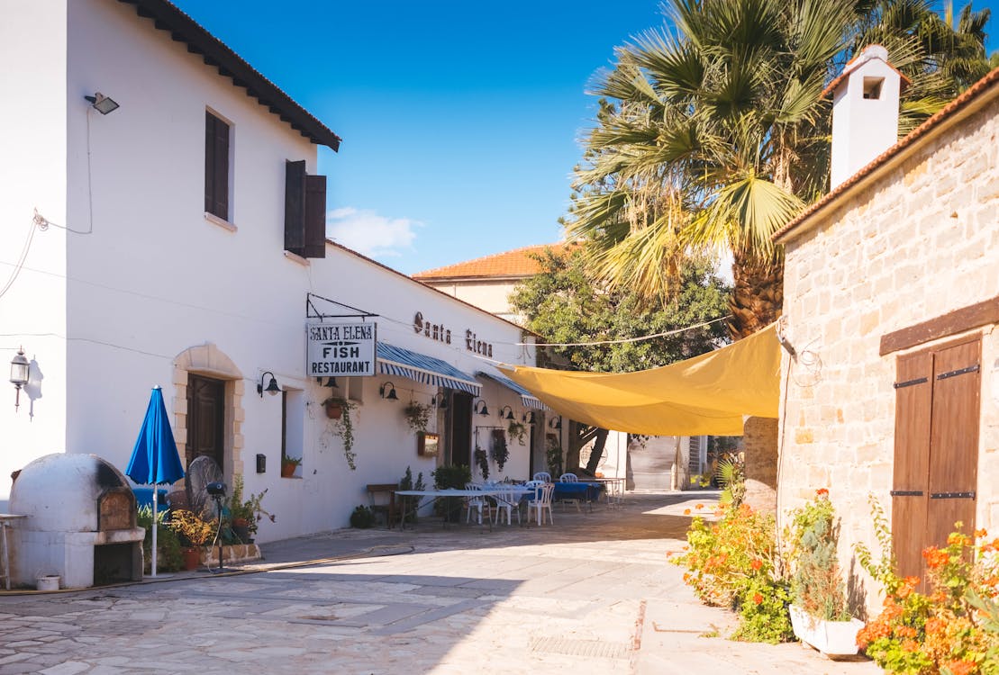 Santa Elena Fish Restaurant with white Mediterranean building, outdoor seating, and shade canopy.