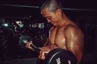 一个坚定的人在健身房举起杠铃，展示力量和健身