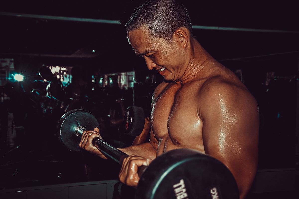 Creatine for muscle growth: benefits, dosage and how to use it | the gym pro Man Lifting A Barbell During Resistance Training