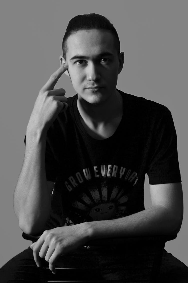 Black And White Studio Shot Of A Man In A T-shirt Sitting On A Chair 