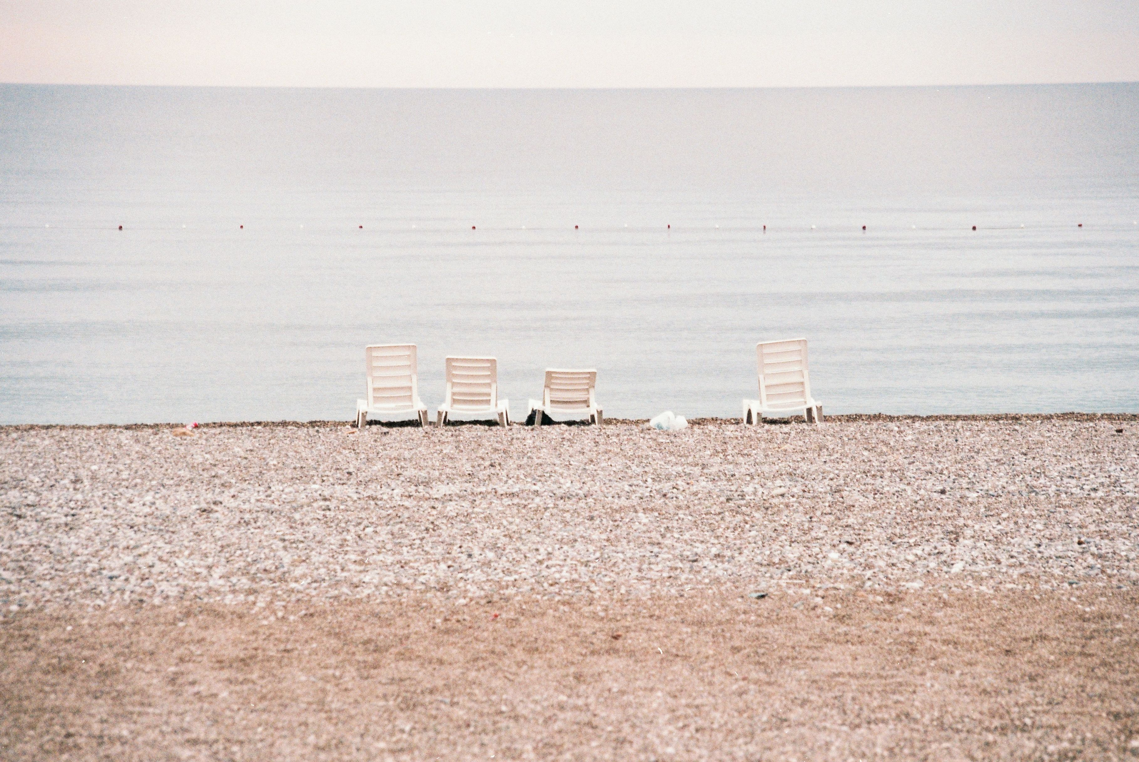 Pissouri Bay beach below white chalk cliffs with sunbeds and a taverna terrace
