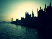 在伦敦，威斯敏斯特宫的优雅剪影映在日落时分的泰晤士河上