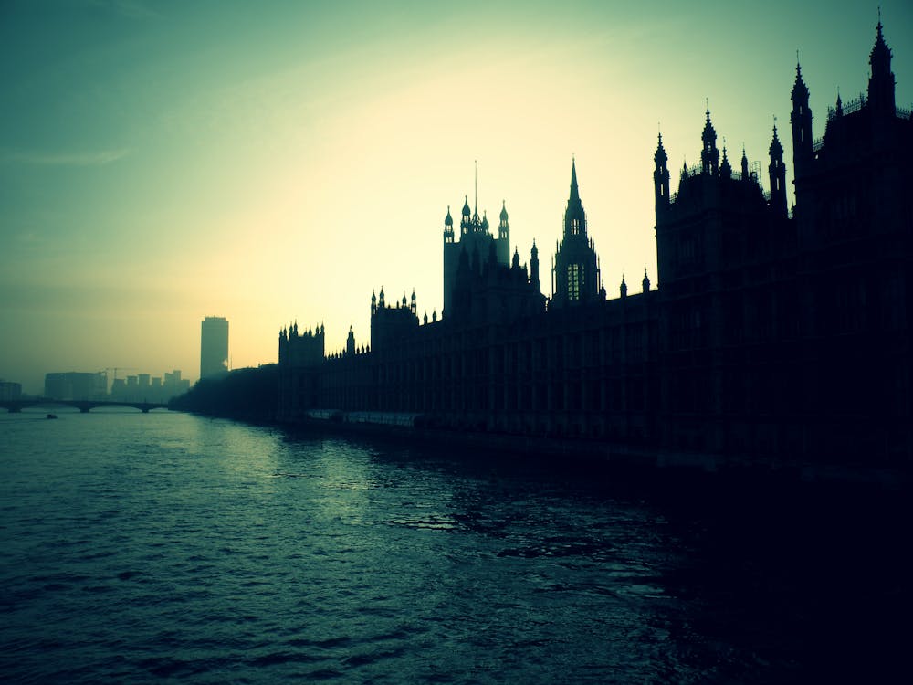 Free Silhouette of High Rise Buildings Beside Body of Water during Golden Hour Stock Photo