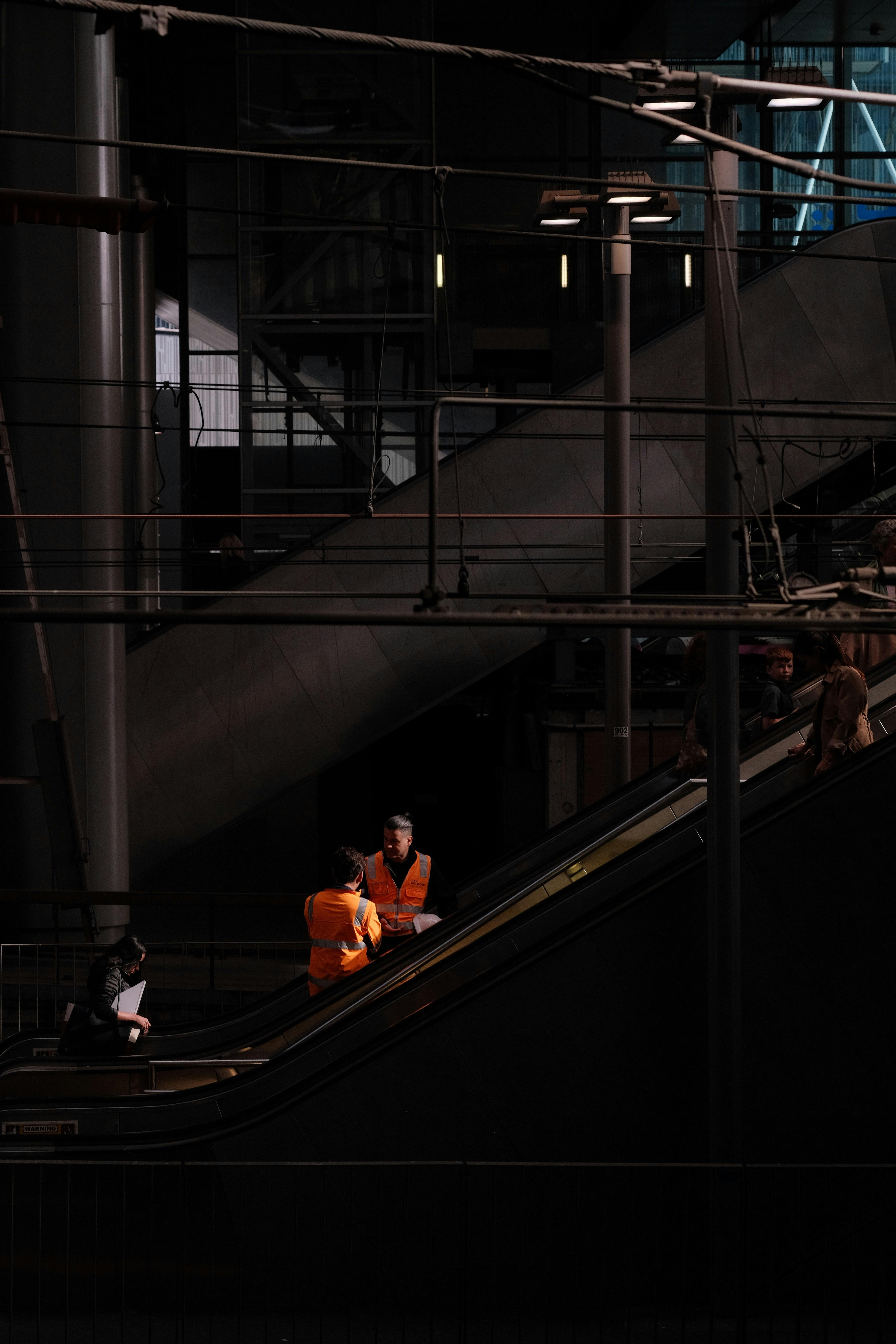 men in reflective vests standing in industrial hall