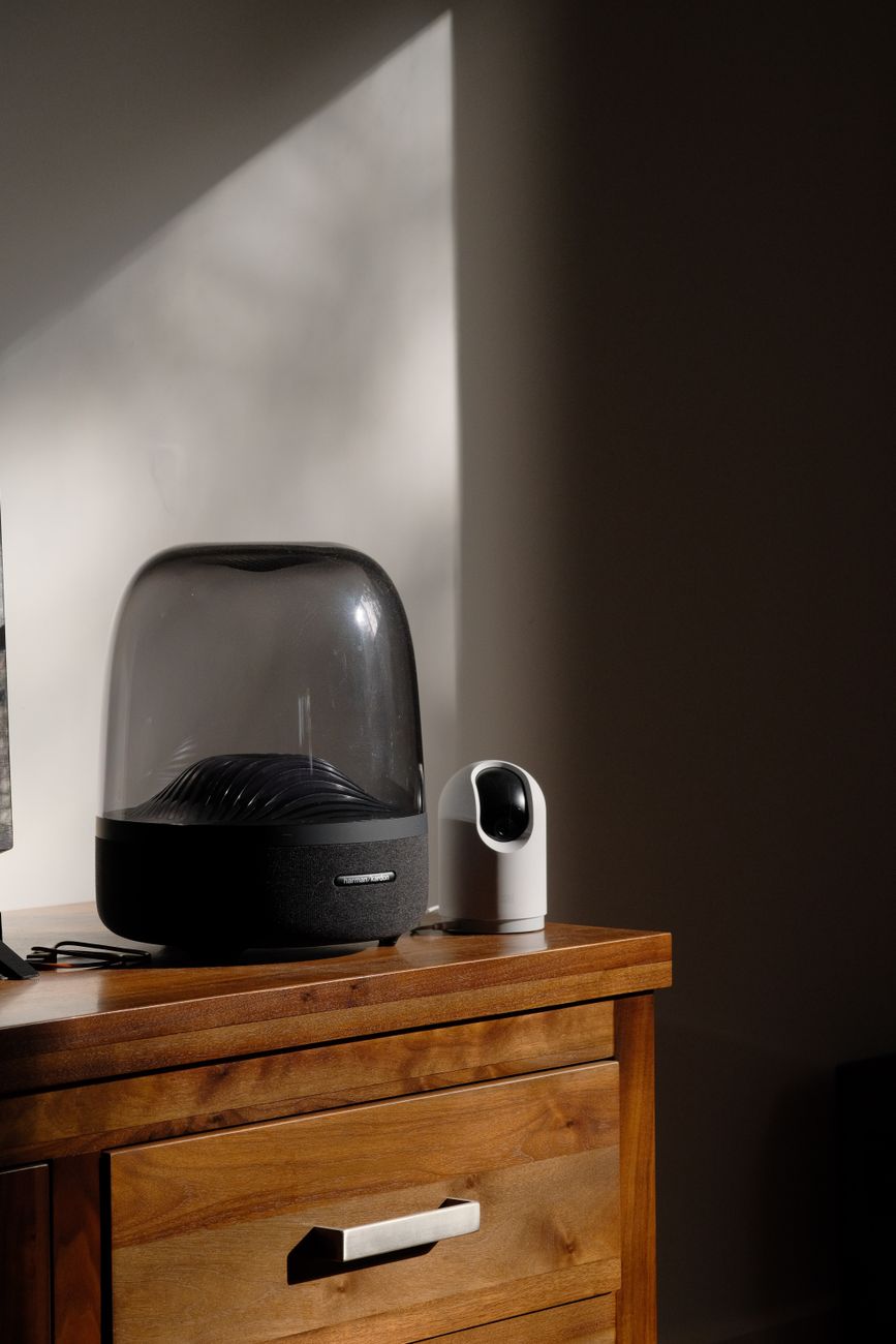Smart speaker and indoor camera on a dresser, the kind of simple kit families use for remote check-ins.