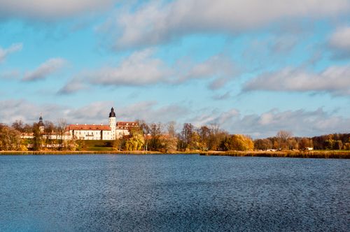 Free Stunning view of Niasviž Castle reflecting in the tranquil lake under a clear sky. Perfect nature and architecture harmony. Stock Photo
