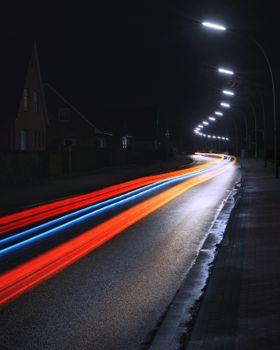 夜间城市街道上，长时间曝光的光路充满活力，展现出动感与速度