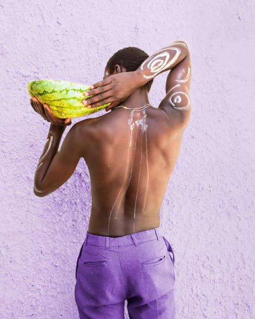 Shirtless Man with Body Painting Holding a Watermelon 