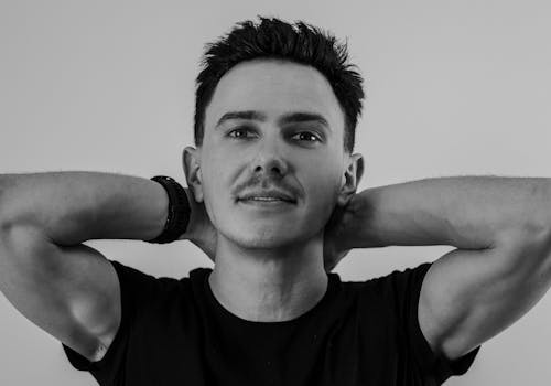 Man Posing with Hands on Neck in Black and White