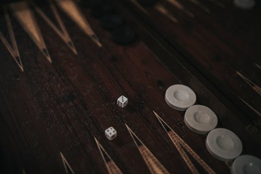 Close-up of a backgammon board with dice and game pieces, creating a moody ambiance.