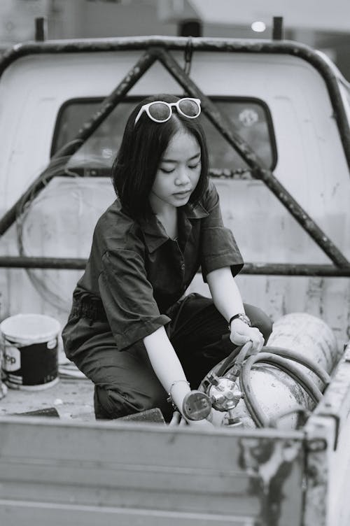 Young Woman Handling a Gas Cylinder on the Pickup Truck 