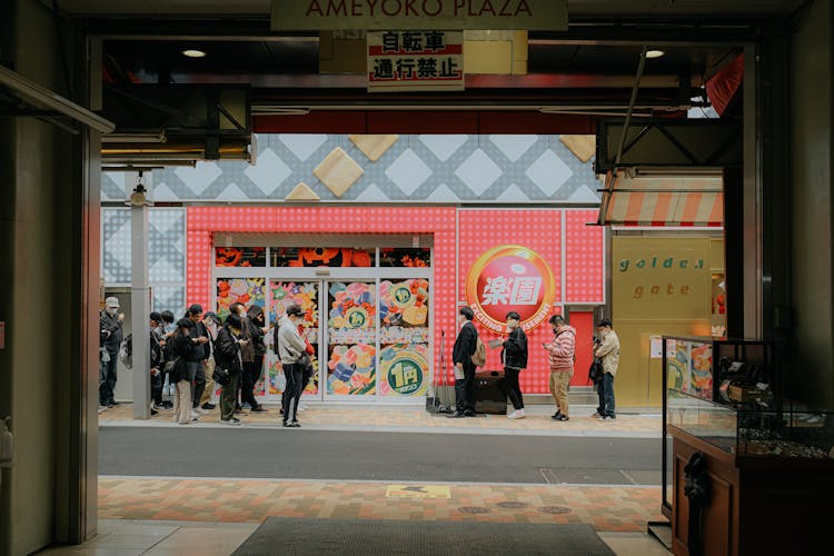 People Waiting In A Queue In Front Of A Store