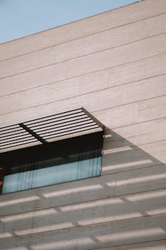 Sunlit exterior of a modern building with shadow patterns in Valencia, Spain.