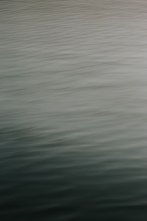 Free Calm water surface with gentle ripples creating a peaceful ambiance. Stock Photo