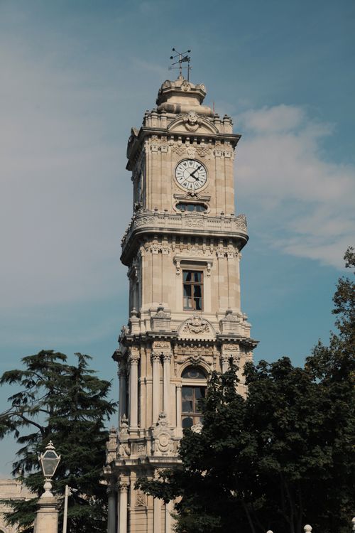 Free A classic view of the Dolmabahçe Clock Tower framed by a clear blue sky in Istanbul, Turkey. Stock Photo