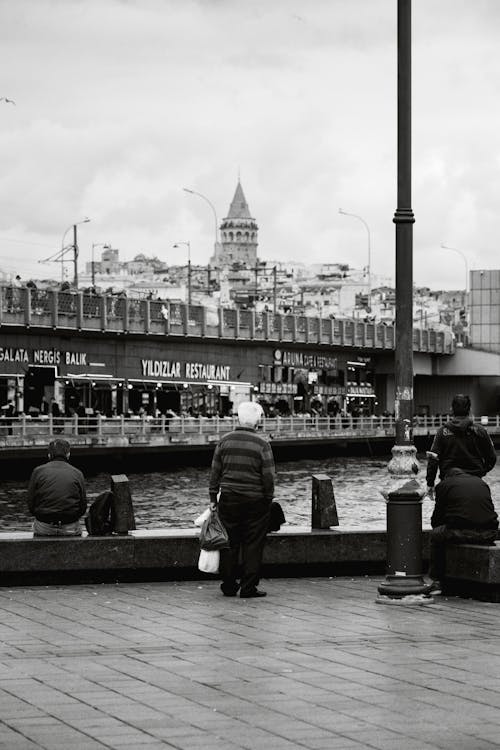 People Standing near the Galata Bridge with the View of the Galata Tower in Istanbul, Turkey 