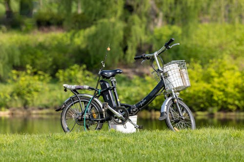 A Bicycle and a Fishing Rod on a Grass Field by the River 