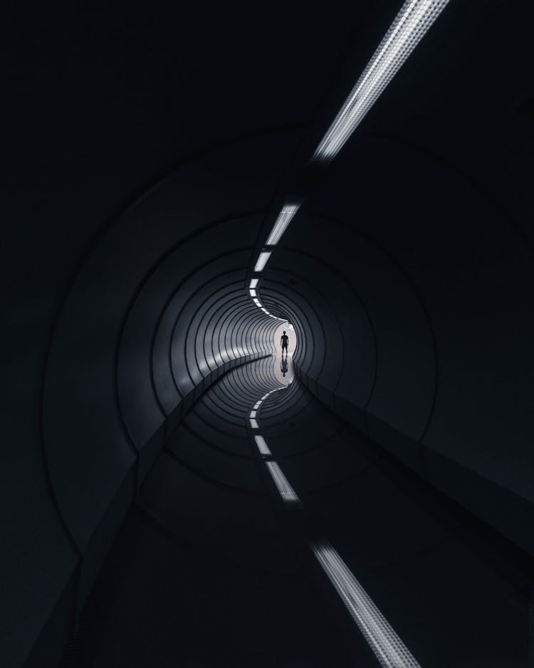 Man Standing At The End Of A Tunnel