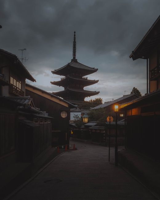 Captivating evening scene of Yasaka Pagoda in the historic streets of Kyōto, Japan, under dramatic clouds.