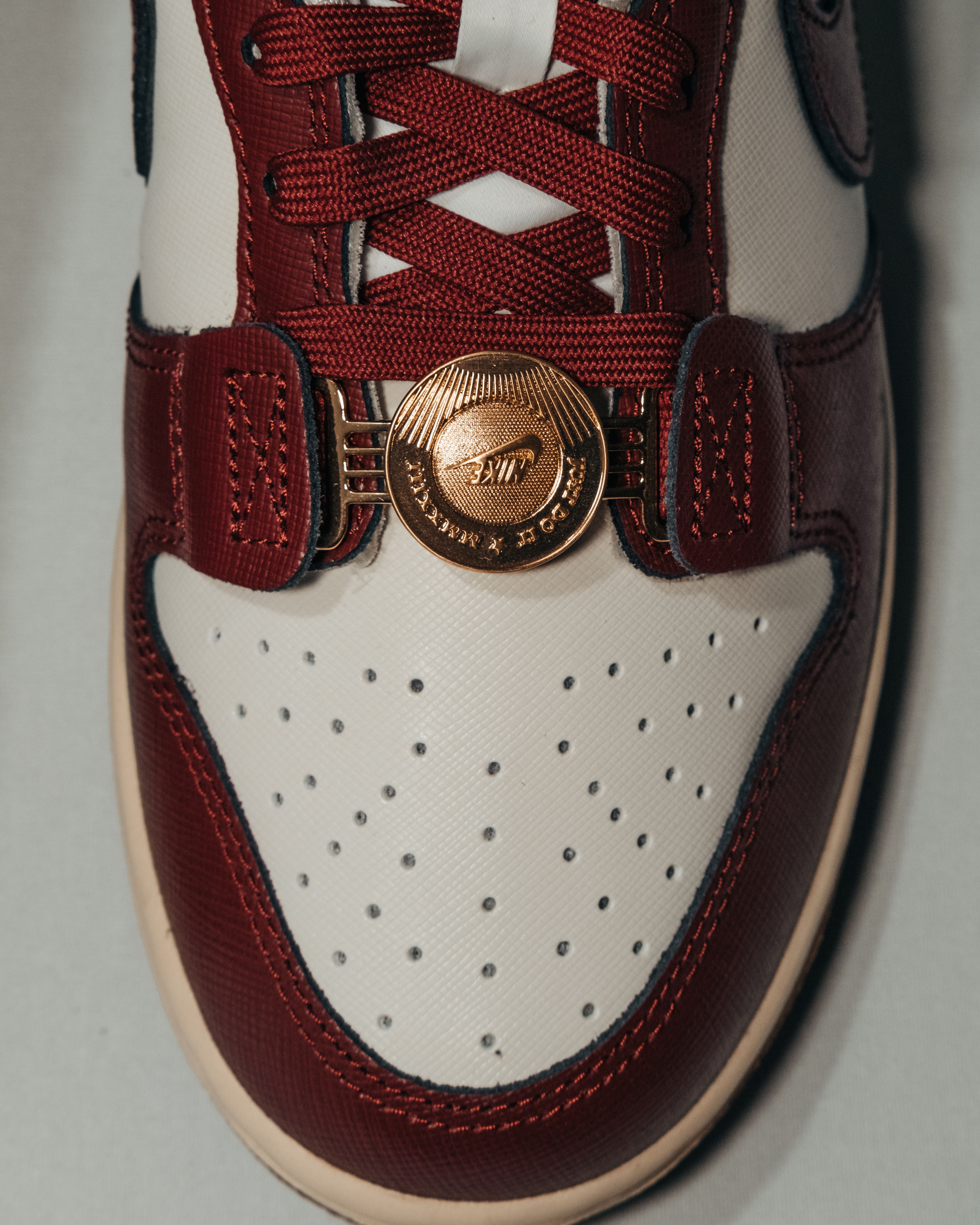 Top view of a fashionable red and white sneaker with gold accent on white background.