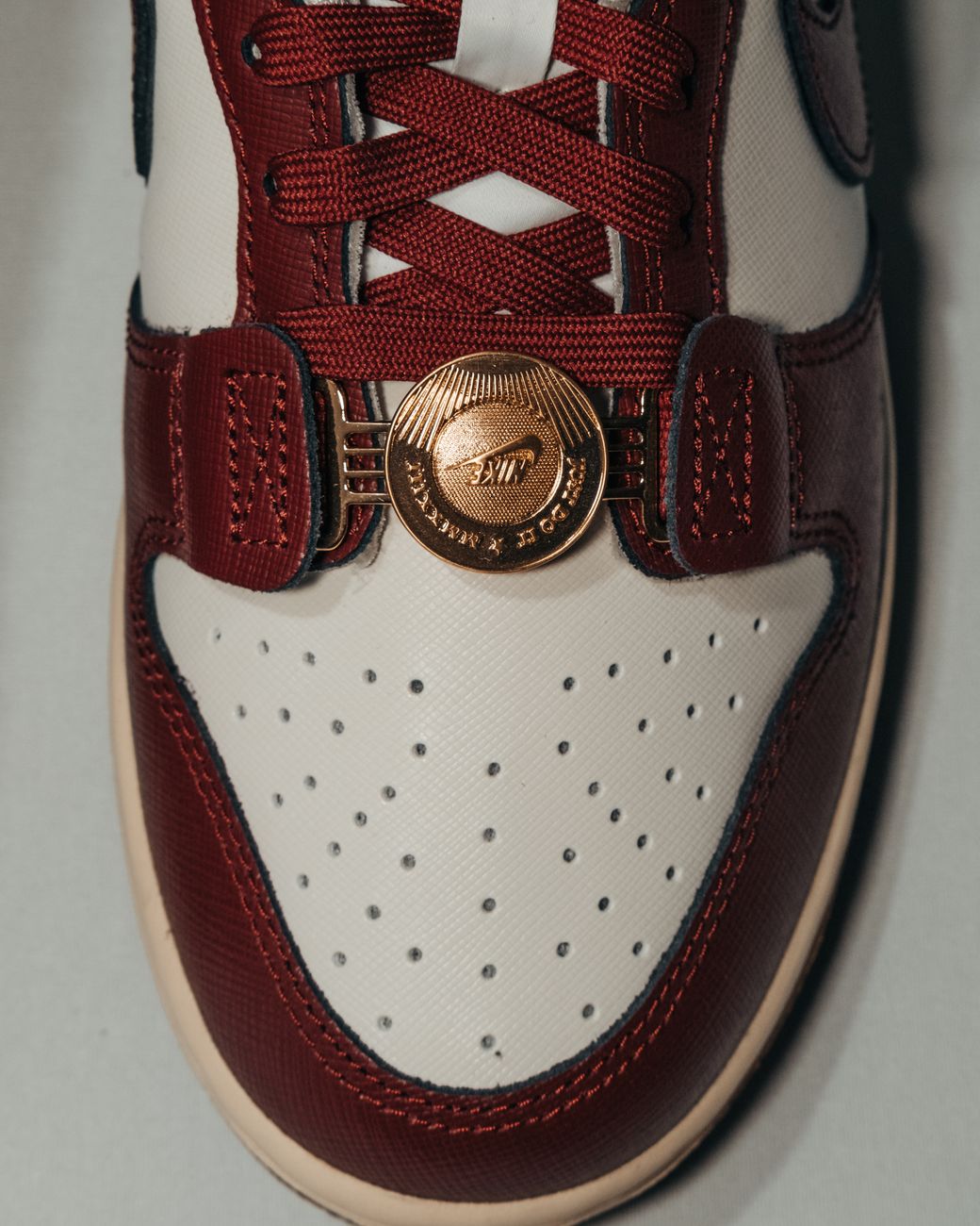 Top view of a fashionable red and white sneaker with gold accent on white background.