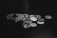 Black and White Photo of Scattered Coins and a Purse
