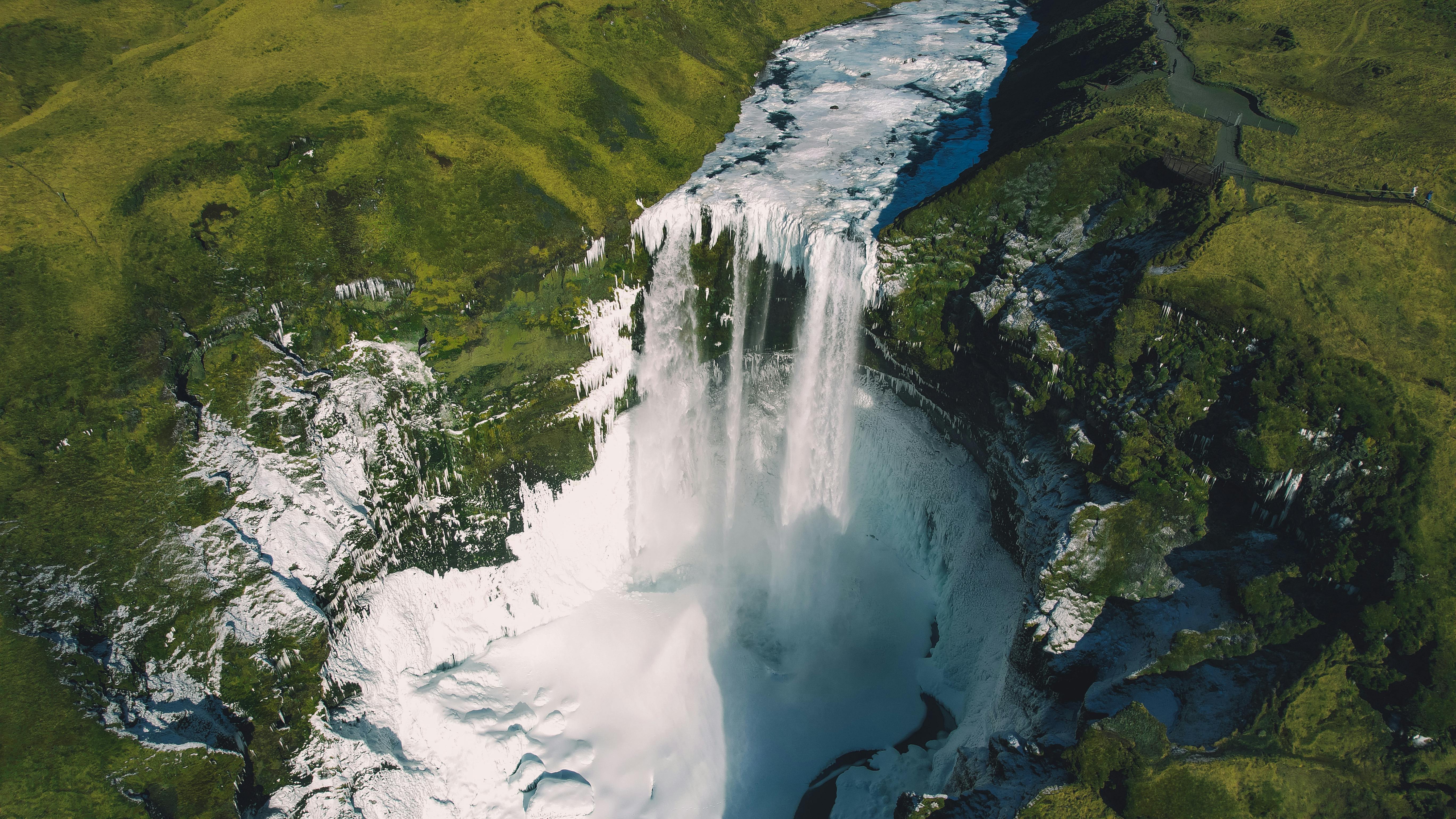 A breathtaking aerial shot of Seljalandsfoss waterfall cascading over lush landscapes in Iceland.