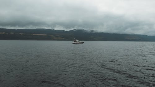 Small Boat on Lake under Cloudy Sky