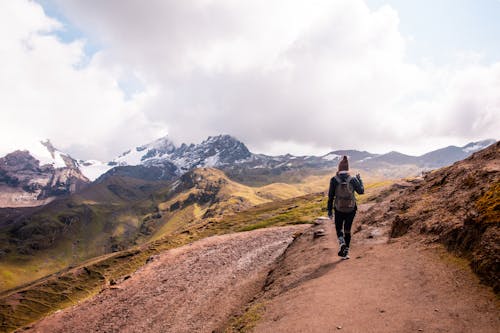 Woman Walking on Path Hiking in Mountains Landscape