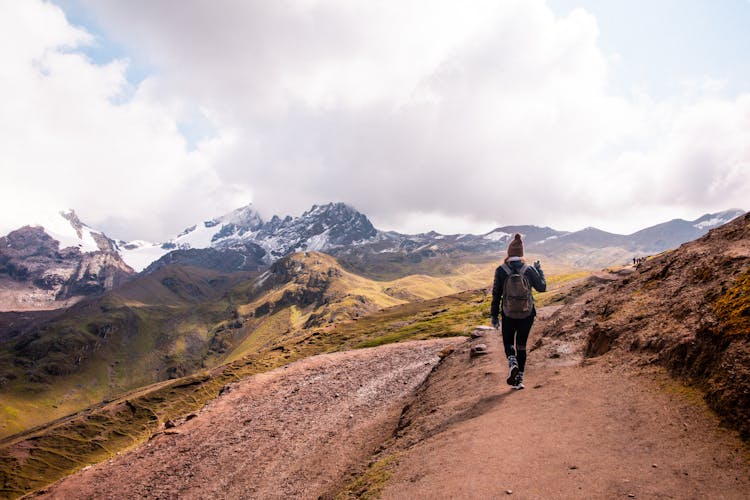 Woman Walking On Path Hiking In Mountains Landscape