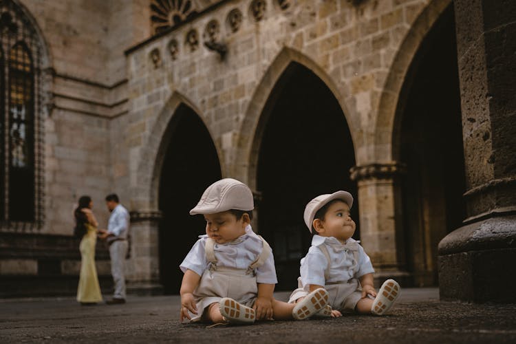 Babies In Shirts Sitting On Pavement