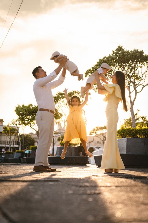 Free A joyful family enjoying playful moments outdoors at sunset, capturing love and togetherness. Stock Photo