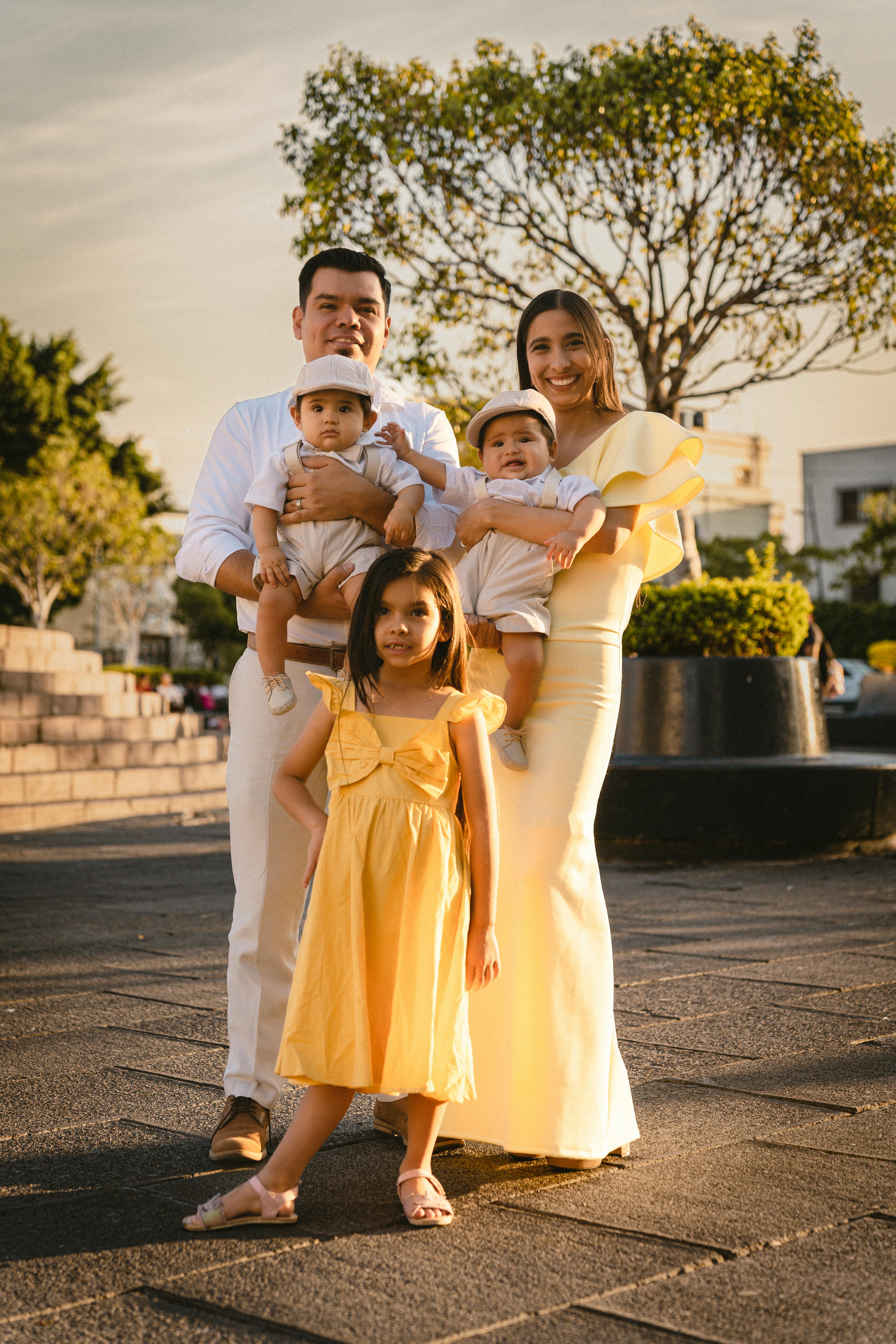Happy family posing outdoors in a sunny urban park together.