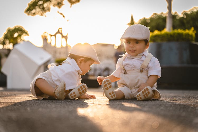 Boys Sitting On Ground At Sunset