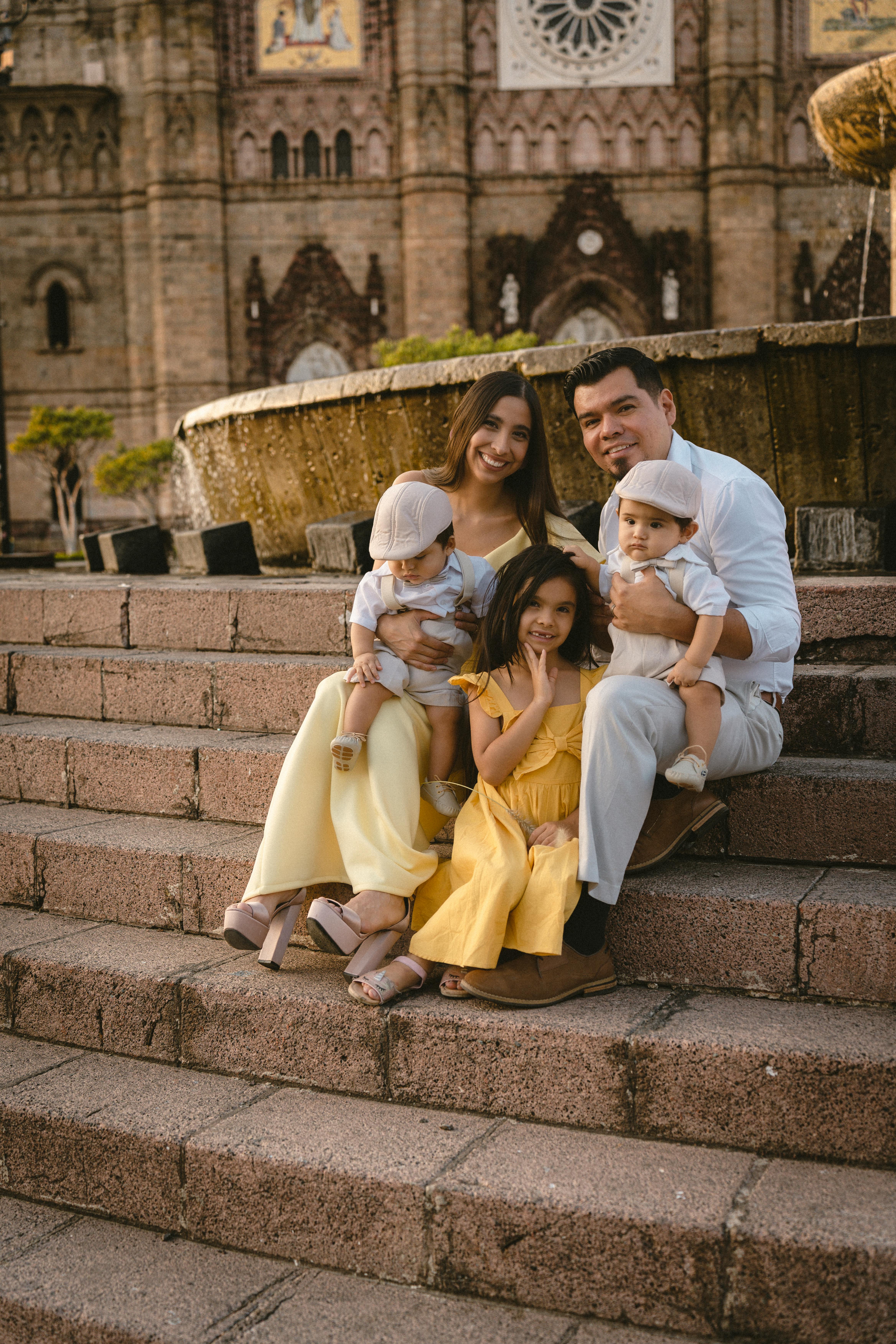 a family with twin baby boys and a daughter posing outdoors