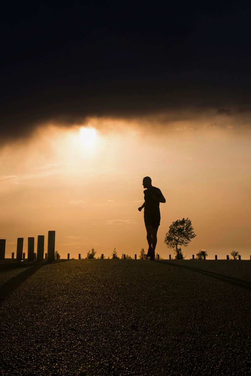 A runner training at dusk as part of an ongoing plan. Photo by NHP&Co on Pexels.