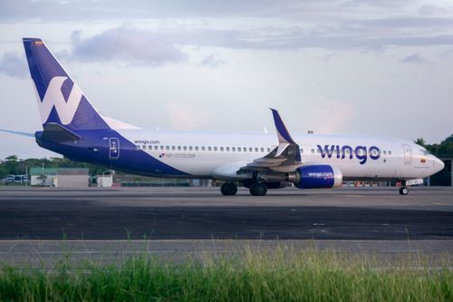 Free Wingo Airlines Boeing 737 parked on an airport tarmac during the day. Stock Photo