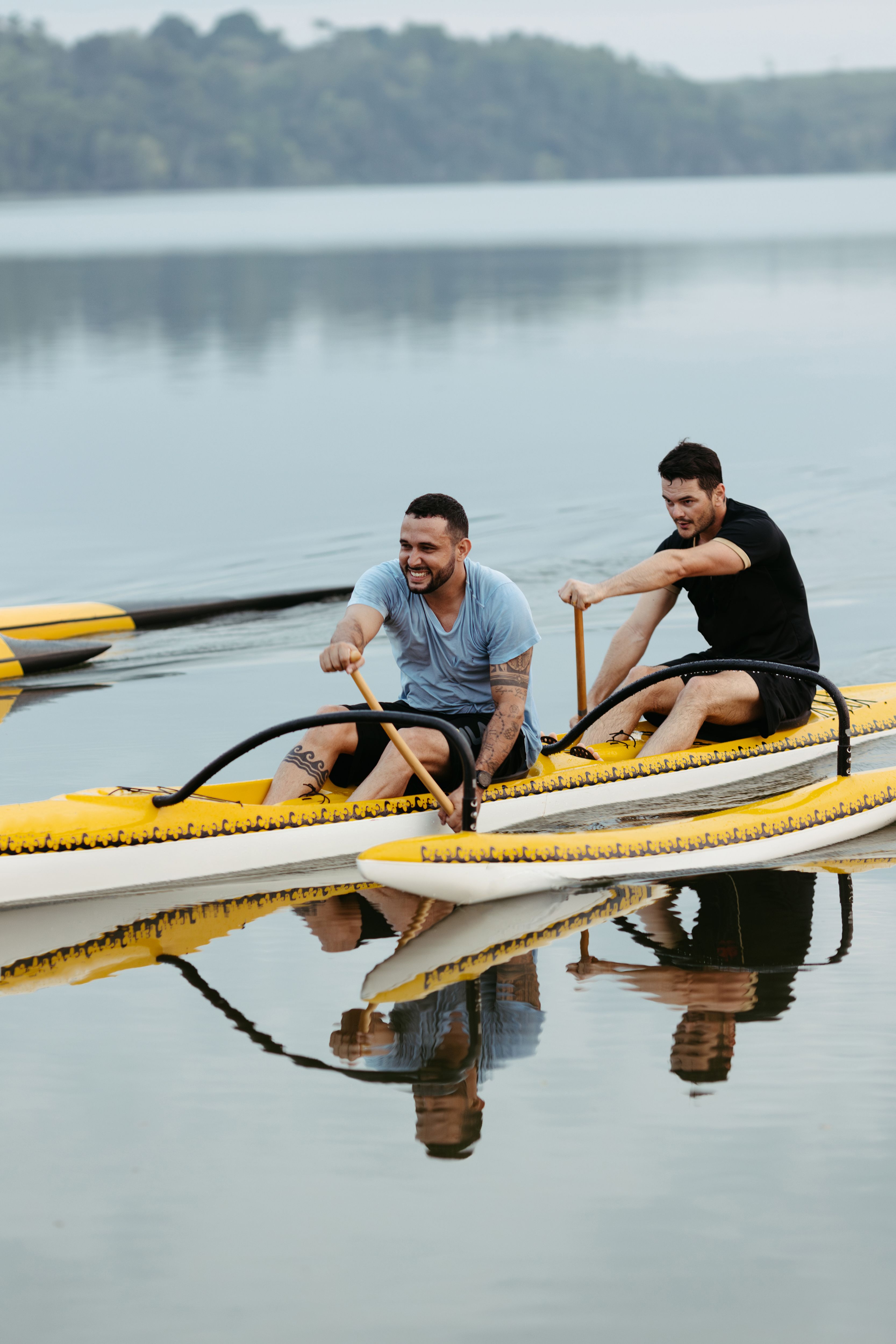 Two men canoeing together on a tranquil lake, enjoying a sunny day outdoors.