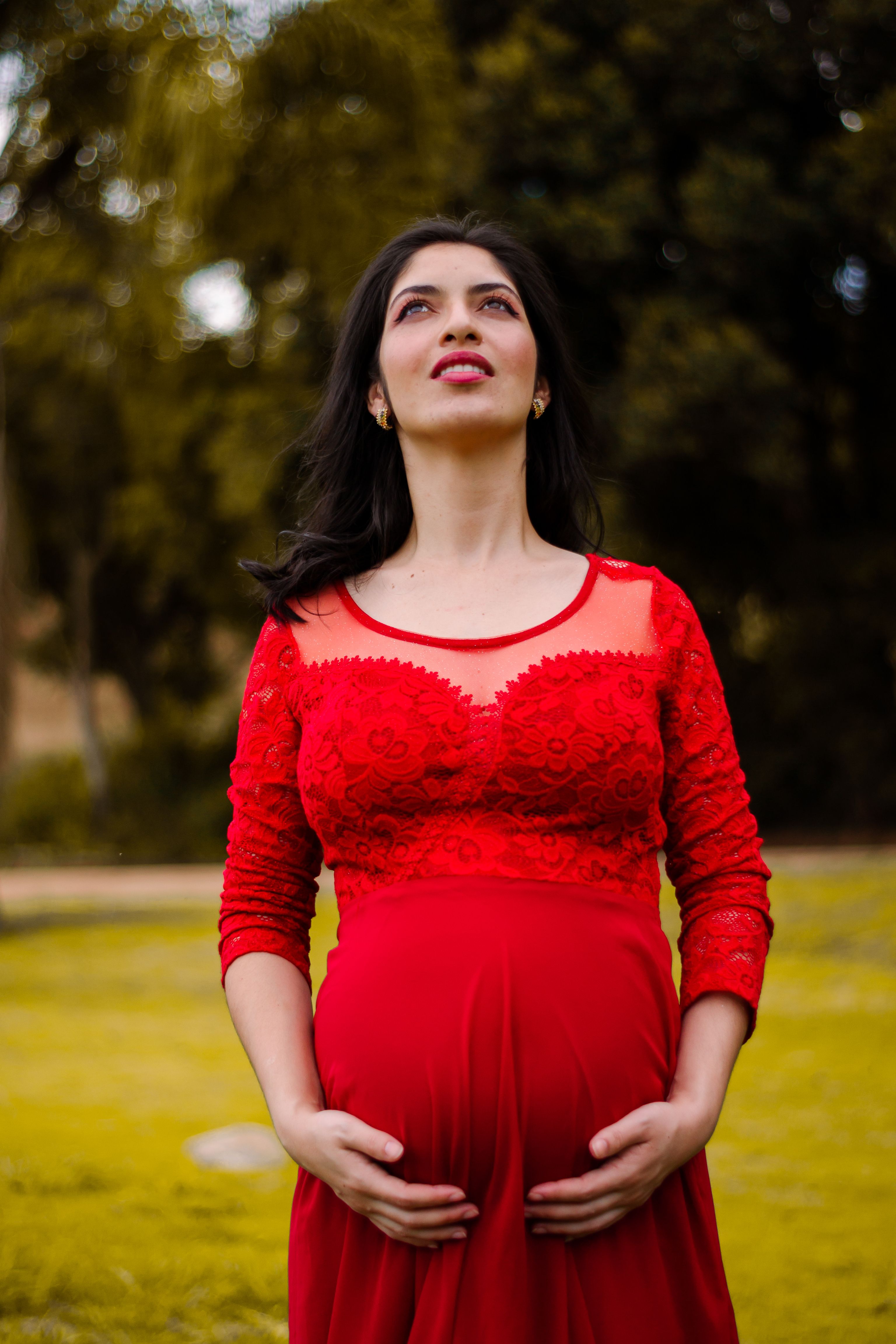 Pregnant Woman Standing in Red Dress  Free Stock Photo