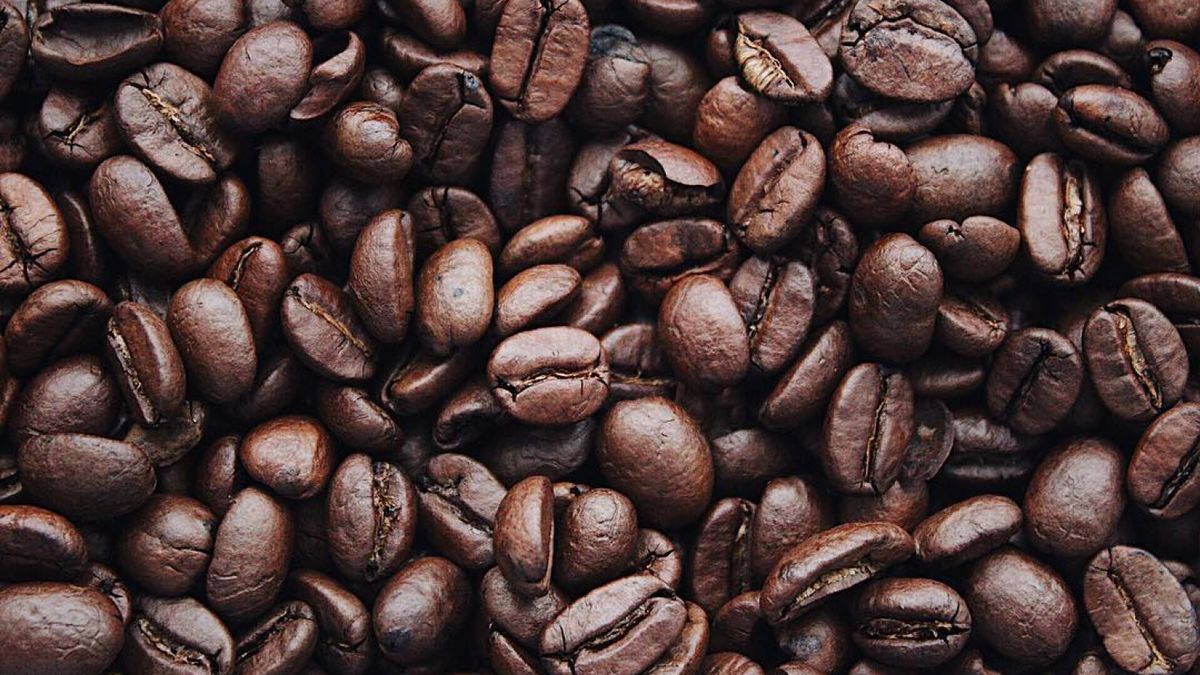 Specialty coffee bag showing a roast date next to freshly roasted single-origin beans