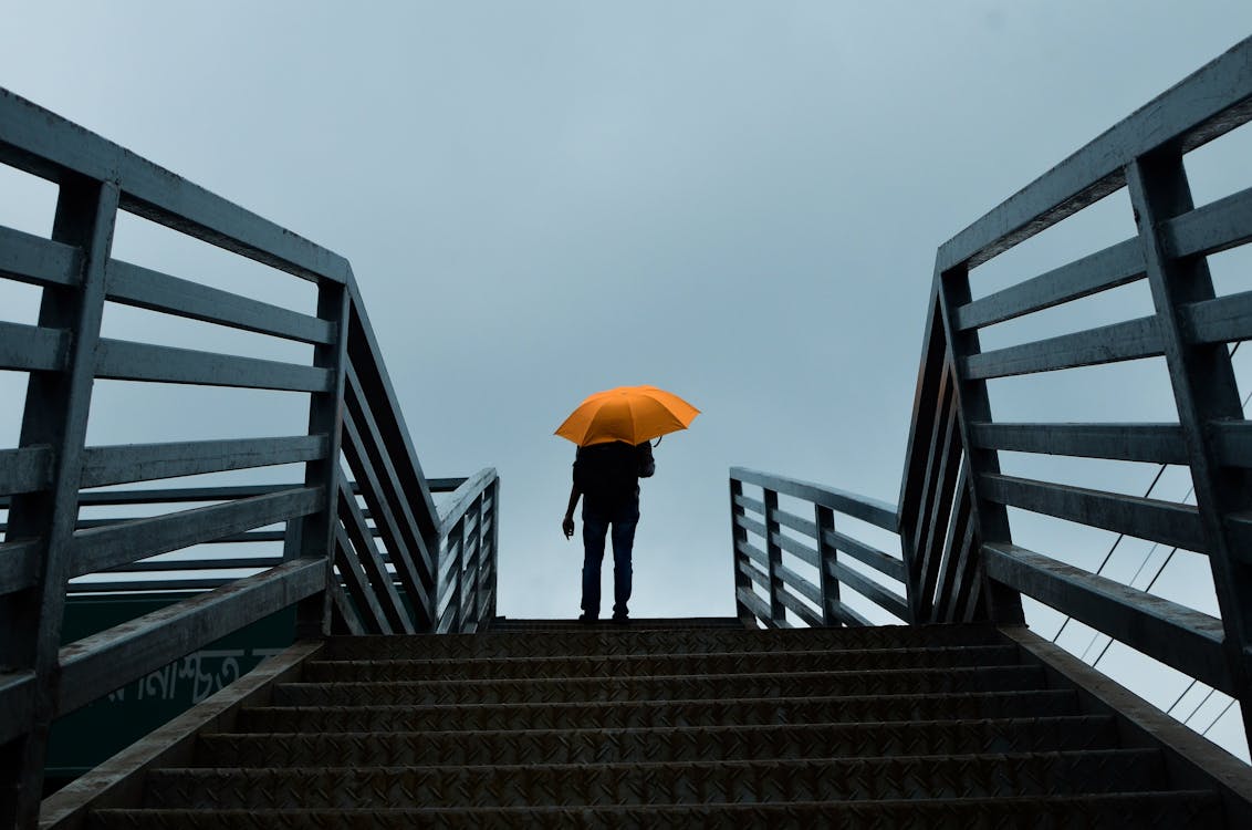 Free Person Holding Umbrella Standing Above Stairs Stock Photo