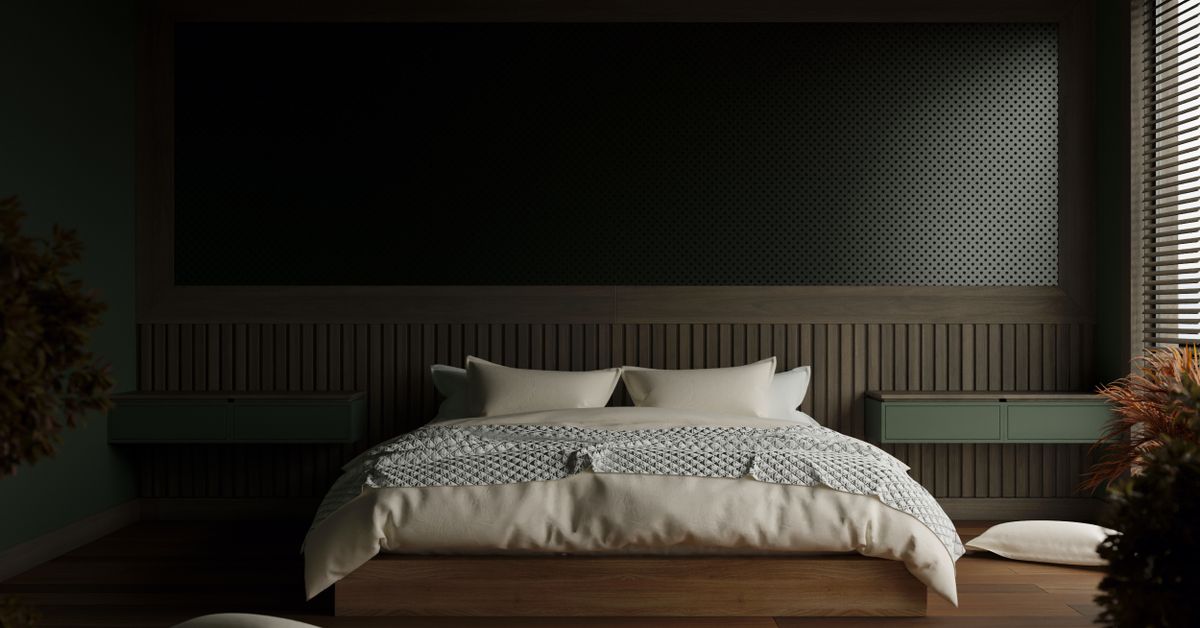 A made bed in a dark, quiet bedroom