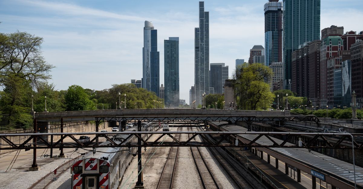 View of Chicago skyline featuring railway tracks and train in urban setting.