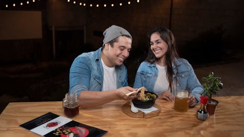 Smiling Couple Eating Soup with Noodles