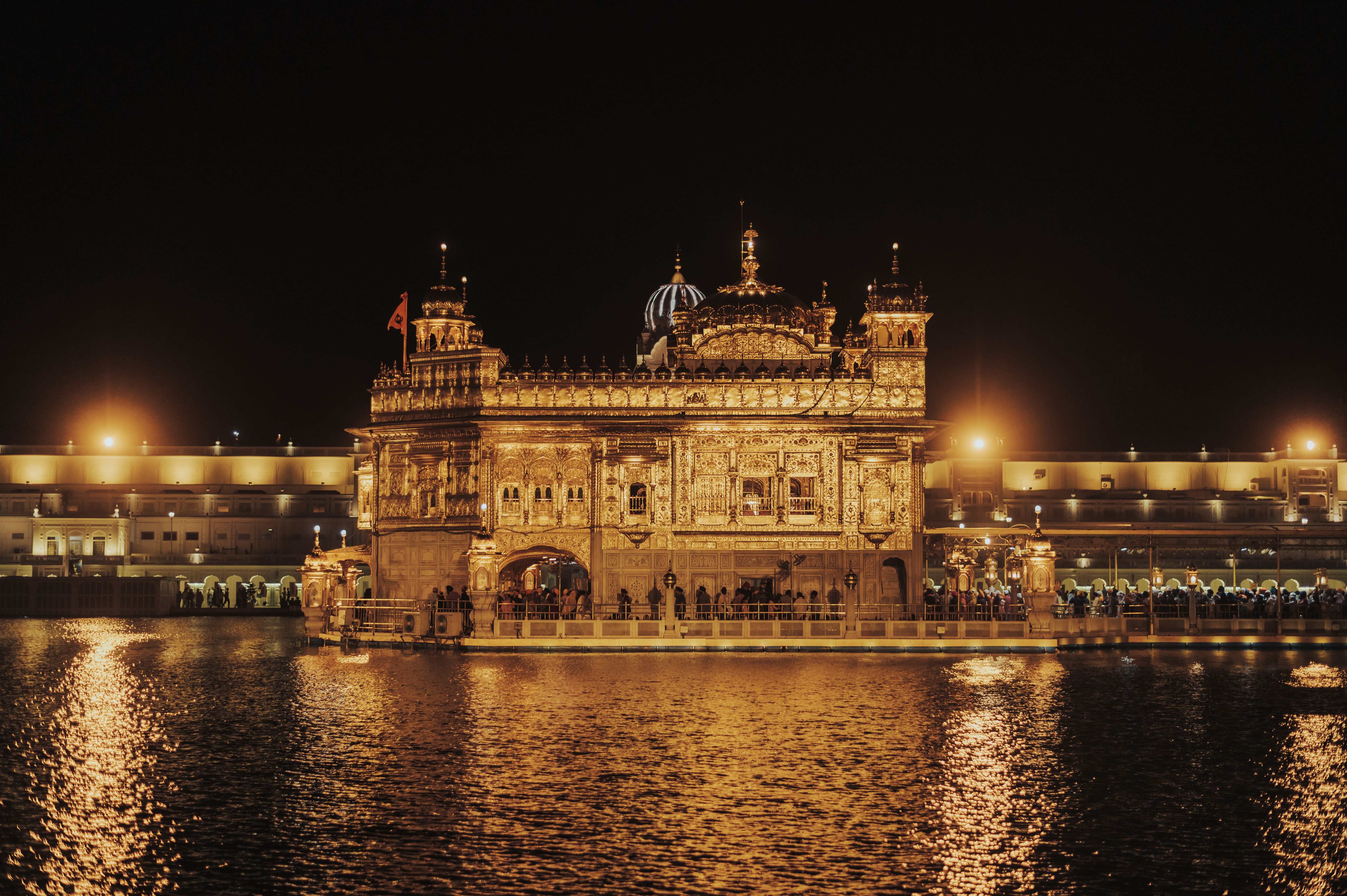 Golden Temple at dawn with pilgrims walking the marble parikrama