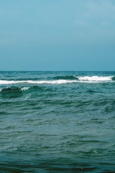 Peaceful ocean scene with gentle waves and a clear blue sky, ideal for relaxation themes.